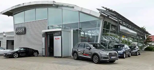 Autohaus Autowelt Bader in Wolfratshausen: Gebäude mit Glasfront und Audi-Logo, davor mehrere Audi-Fahrzeuge